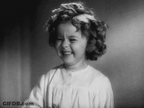 A Black And White Photo Of A Little Girl Smiling . GIF