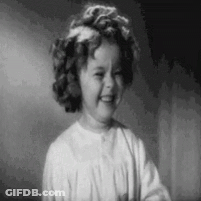 A Black And White Photo Of A Little Girl Smiling In A Room . GIF