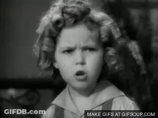 A Black And White Photo Of A Little Girl With Curlers In Her Hair Making A Face . GIF