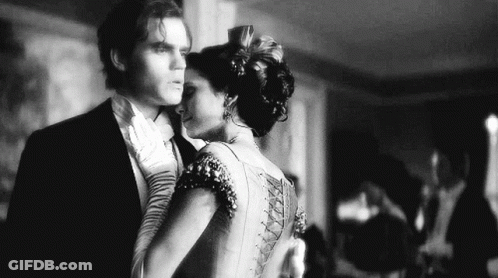 A Black And White Photo Of A Man And A Woman Dancing Together . GIF