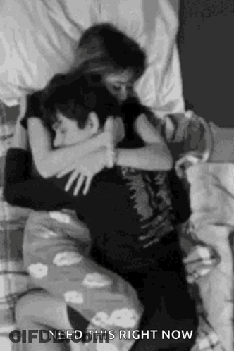 A Black And White Photo Of A Man And A Woman Hugging Each Other . GIF