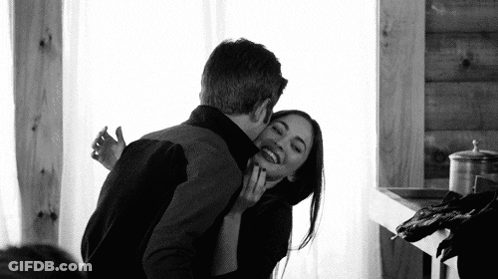 A Black And White Photo Of A Man And A Woman Hugging Each Other . GIF