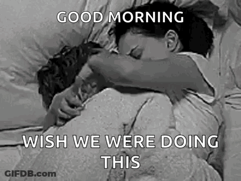 A Black And White Photo Of A Man And A Woman Hugging Each Other In Bed . GIF