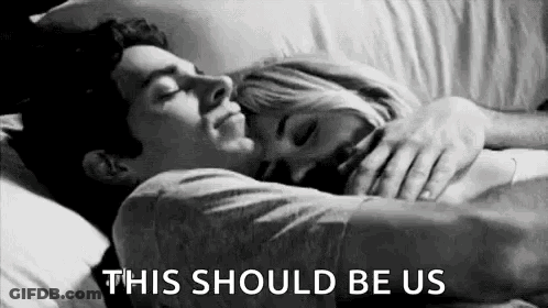 A Black And White Photo Of A Man And A Woman Hugging Each Other In Bed . GIF
