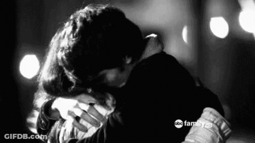A Black And White Photo Of A Man And A Woman Hugging Each Other . GIF