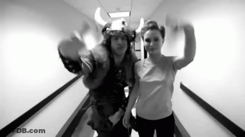 A Black And White Photo Of A Man And A Woman In A Hallway . GIF