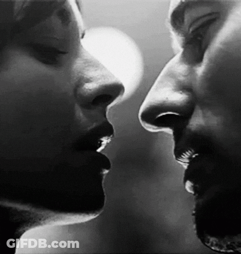 A Black And White Photo Of A Man And A Woman Kissing . GIF