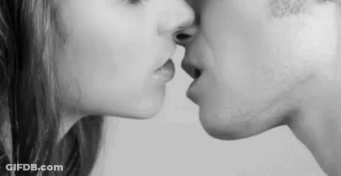 A Black And White Photo Of A Man And A Woman Kissing . GIF