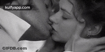 A Black And White Photo Of A Man And A Woman Kissing . GIF
