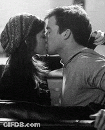 A Black And White Photo Of A Man And A Woman Kissing In A Car . GIF
