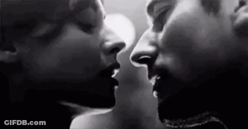 A Black And White Photo Of A Man And A Woman Kissing . GIF
