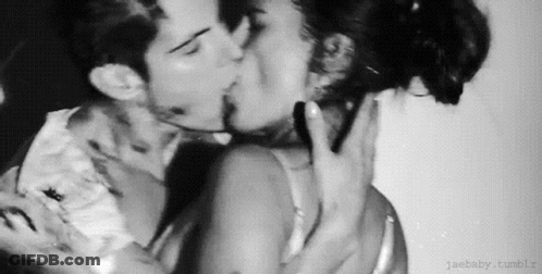 A Black And White Photo Of A Man And A Woman Kissing . GIF