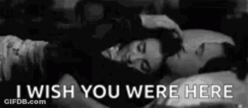 A Black And White Photo Of A Man And A Woman Laying In Bed With The Words `` I Wish You Were Here '' . GIF