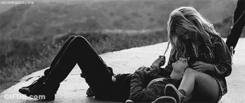 A Black And White Photo Of A Man And A Woman Laying On The Ground GIF