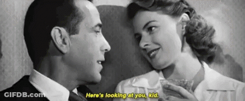 A Black And White Photo Of A Man And A Woman Looking At Each Other . GIF