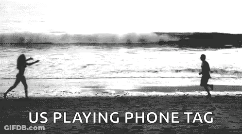 A Black And White Photo Of A Man And A Woman Playing Frisbee On A Beach . GIF