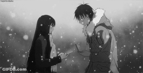 A Black And White Photo Of A Man And A Woman Standing In The Snow . GIF