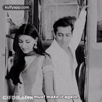 A Black And White Photo Of A Man And A Woman Standing Next To Each Other On A Train . GIF
