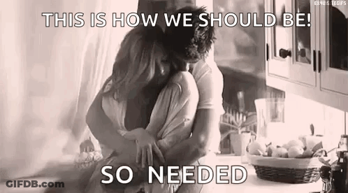 A Black And White Photo Of A Man And Woman Hugging Each Other In A Kitchen . GIF