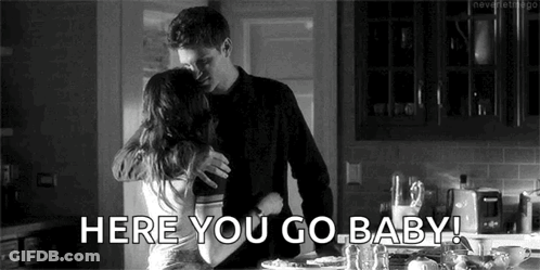 A Black And White Photo Of A Man And Woman Hugging Each Other In A Kitchen . GIF