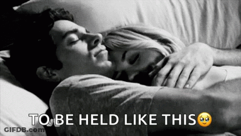 A Black And White Photo Of A Man And Woman Hugging With The Words To Be Held Like This Below Them GIF