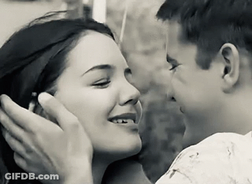 A Black And White Photo Of A Man And Woman Kissing . GIF