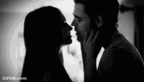 A Black And White Photo Of A Man And Woman Kissing Each Other . GIF