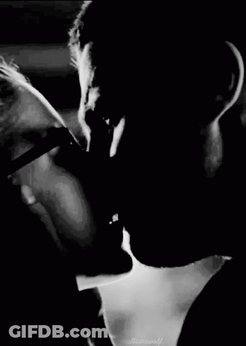 A Black And White Photo Of A Man And Woman Kissing Each Other . GIF