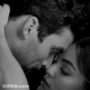 A Black And White Photo Of A Man And Woman Kissing Each Other . GIF
