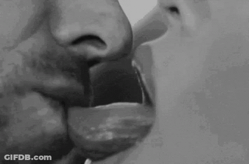 A Black And White Photo Of A Man And Woman Kissing Each Other . GIF