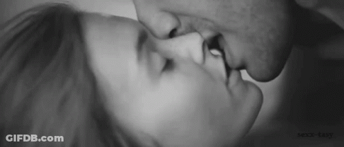 A Black And White Photo Of A Man And Woman Kissing Each Other . GIF