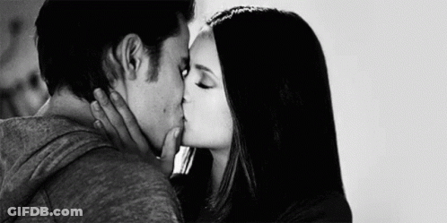A Black And White Photo Of A Man And Woman Kissing Each Other . GIF