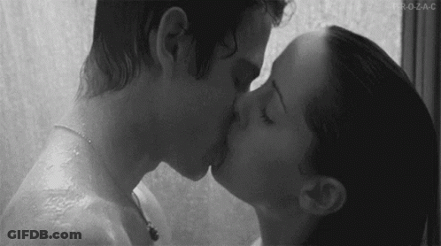 A Black And White Photo Of A Man And Woman Kissing In The Shower . GIF