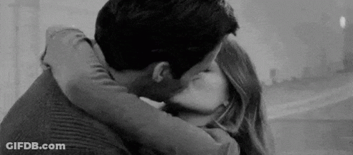 A Black And White Photo Of A Man And Woman Kissing . GIF