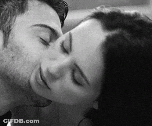 A Black And White Photo Of A Man And Woman Kissing With Their Eyes Closed . GIF