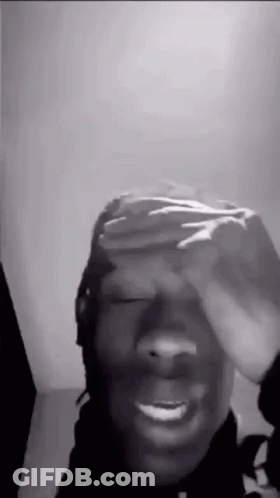 A Black And White Photo Of A Man Covering His Eyes With His Hand . GIF