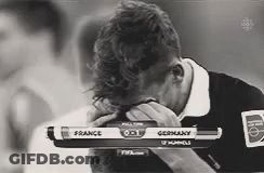 A Black And White Photo Of A Man Covering His Face While Watching A Game Between France And Germany GIF