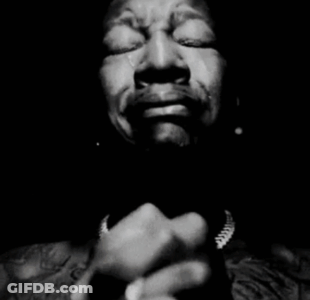 A Black And White Photo Of A Man Covering His Mouth With His Hands GIF
