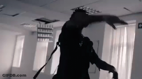 A Black And White Photo Of A Man Dancing In A Room With A Fire Exit Sign . GIF