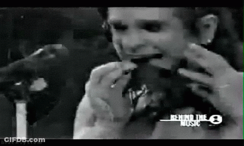 A Black And White Photo Of A Man Eating A Hamburger With Behind The Music Written On The Bottom GIF