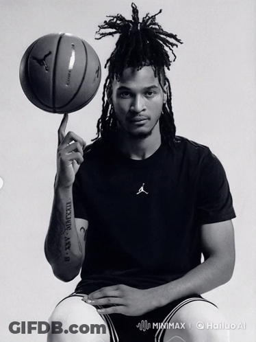 A Black And White Photo Of A Man Holding A Basketball With Roman Numerals On His Arm GIF