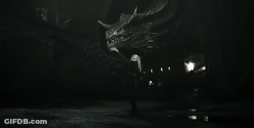 A Black And White Photo Of A Man Holding A Large Dragon GIF