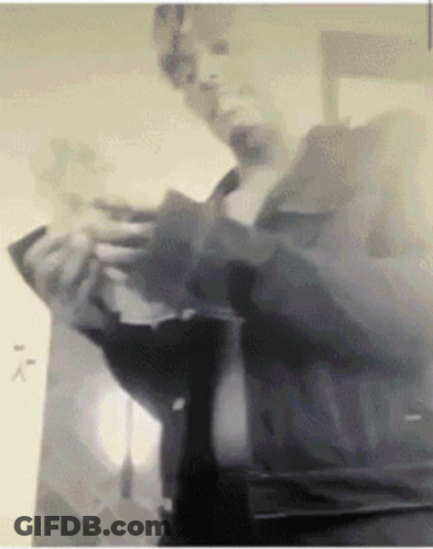 A Black And White Photo Of A Man Holding A Piece Of Paper GIF