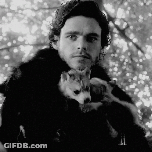 A Black And White Photo Of A Man Holding A Puppy . GIF
