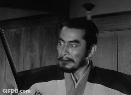 A Black And White Photo Of A Man Holding A Sword GIF