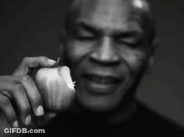 A Black And White Photo Of A Man Holding An Apple GIF