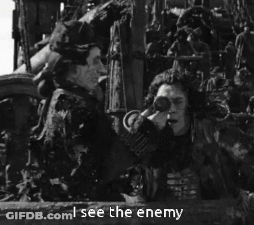 A Black And White Photo Of A Man Holding Binoculars With The Words " I See The Enemy " Below Him GIF