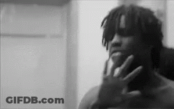 A Black And White Photo Of A Man Holding His Hand To His Face . GIF