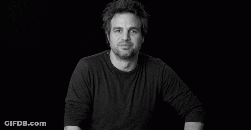 A Black And White Photo Of A Man In A Black Shirt Smiling . GIF