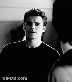 A Black And White Photo Of A Man In A Black Shirt Talking To Another Man GIF